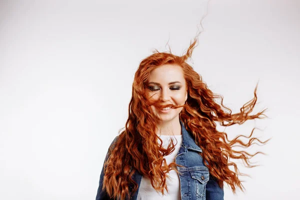 Portrait of beautiful cheerful redhead girl with flying curly hair