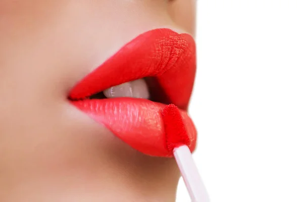 Primer plano de los labios de la mujer con maquillaje de moda. Maquillaje de labios de tendencia con lápiz labial de color rojo brillante. Mujer aplicando maquillaje de labios de moda. Macro de maquillaje hermoso en los labios llenos. Elección de lápiz labial — Foto de Stock