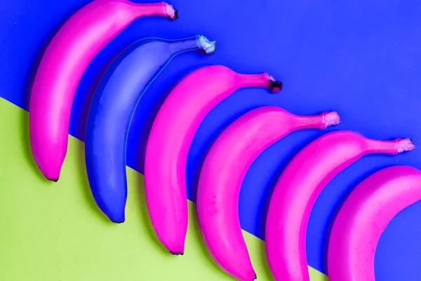 Foto abstracta muchos plátanos de color azul y rosa sobre un fondo multicolor — Foto de Stock