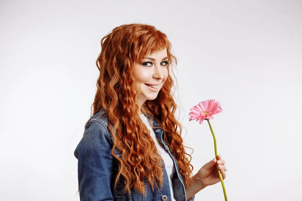 Retrato de uma mulher muito caucasiana sorrindo e segurando flor no fundo branco — Fotografia de Stock