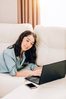 Dizüstü bilgisayar evde kanepede kullanan Bbeautiful kadın