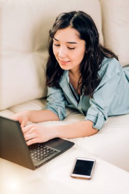 Dizüstü bilgisayar evde kanepede kullanan Bbeautiful kadın