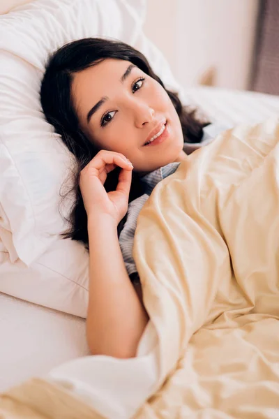 Portrait pretty young girl on bed in modern apartment in the morning — Stock Photo, Image