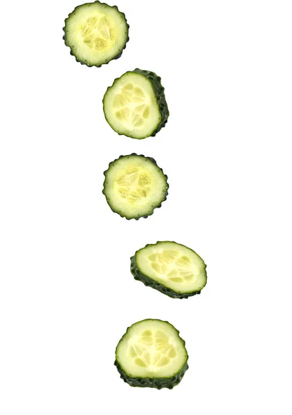 Close-up van stukken van de verse rijpe groene komkommer vallen op witte achtergrond — Stockfoto