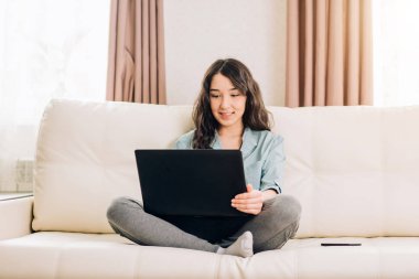 Dizüstü bilgisayar evde kanepede kullanan Bbeautiful kadın