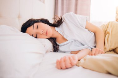 Yatakta uyurken, sabah rahatlatıcı genç güzel kadın