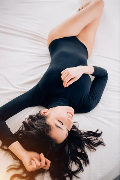 Stående ganska sexig ung kvinna på sängen — Stockfoto