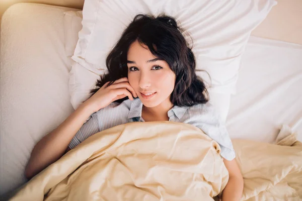 Retrato menina bonita na cama no apartamento moderno pela manhã — Fotografia de Stock