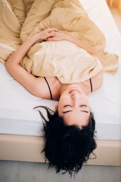 Porträtt söt ung flicka på sängen i modern lägenhet på morgonen — Stockfoto