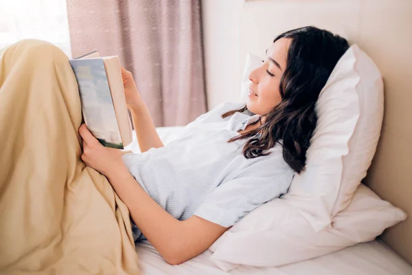 Portrait pretty young girl on bed in modern apartment in the morning