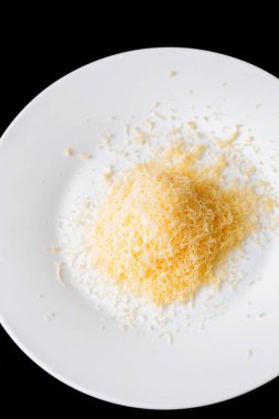 Bir siyah bir büyük beyaz seramik tabak içinde rendelenmiş peynir rendelenmiş