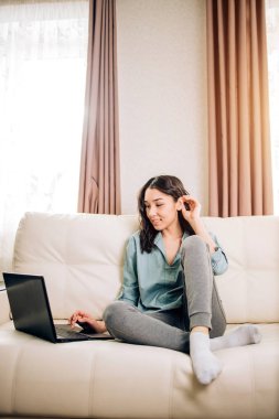 Dizüstü bilgisayar evde kanepede kullanan Bbeautiful kadın