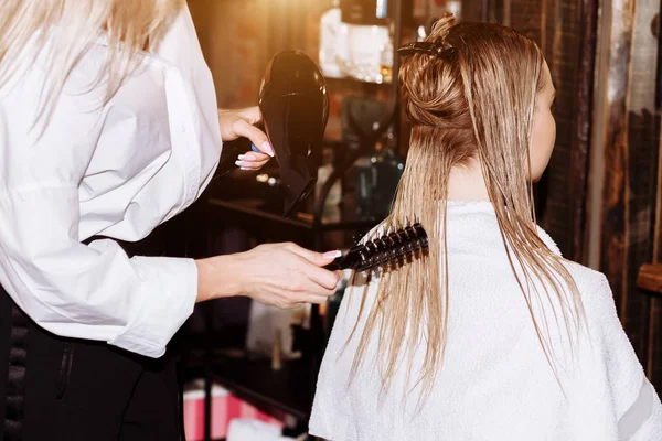 Close-up de cabeleireiro mulher fazendo penteado ao cliente com cabelo loiro longo — Fotografia de Stock