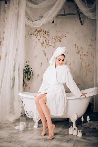 Jolie fille portant un peignoir blanc et une serviette sur la tête dans la salle de bain — Photo