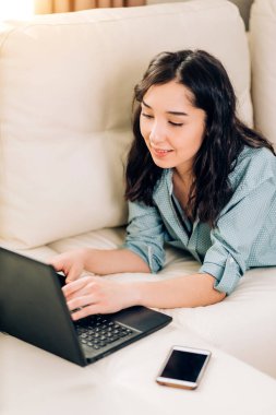 Dizüstü bilgisayar evde kanepede kullanan Bbeautiful kadın