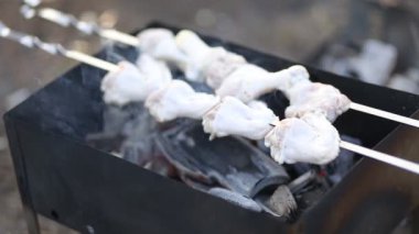 Çiğ tavuk uyluk Closeup, kömür ile ızgara üzerinde barbekü açık havada