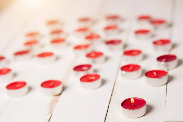 Lindas velas vermelhas em chamas no fundo de madeira branco — Fotografia de Stock