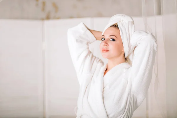 Junge lächelnde Frau im Bademantel mit Handtuch auf dem Kopf — Stockfoto