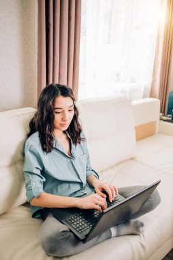 Dizüstü bilgisayar evde kanepede kullanan Bbeautiful kadın
