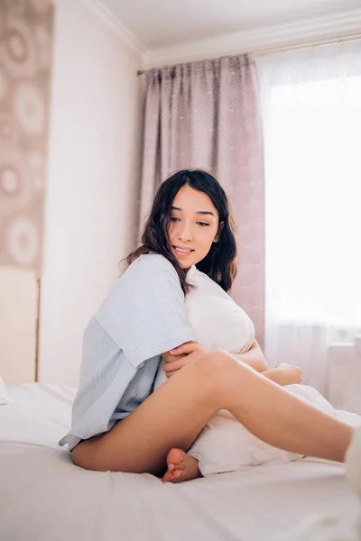 Женщина, сидящая в постели по утрам — стоковое фото