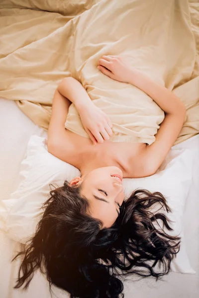 Portrait pretty young girl on bed in modern apartment in the morning — Stock Photo, Image