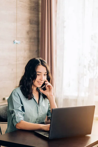 Happy young woman using laptop at home