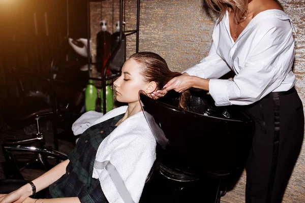 Saç modeli yapmadan önce müşterisine hairstilist yıkamak. Güzellik salonunda kadın saçları üzerinde Besleyici maske uygulayan Kuaför. — Stok fotoğraf