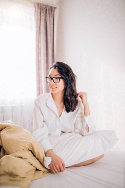 Güzel kadın sabah yatakta oturuyordu