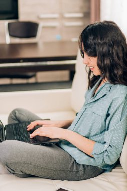 Dizüstü bilgisayar evde kanepede kullanan Bbeautiful kadın