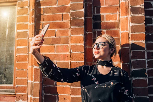 Mooie schattige blonde model in jurk poseren in de stad — Stockfoto