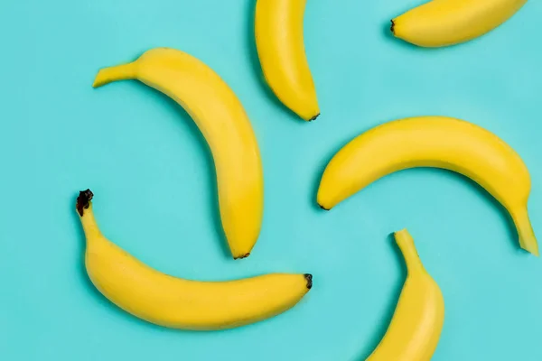 Colocação plana de bananas no fundo azul — Fotografia de Stock