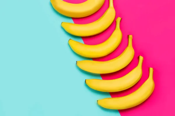 Bananas amarelas maduras em um fundo colorido de papel com espaço de cópia. vista superior — Fotografia de Stock