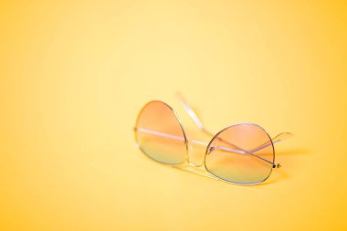 Sarı arkaplanda güneş gözlüğü