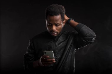 Siyah adam karanlıkta cep telefonu tutan