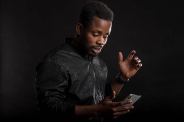 Siyah adam karanlıkta cep telefonu tutan