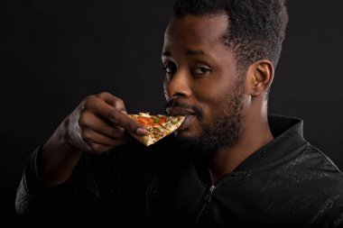 Pizza yiyen afrikalı genç adamın yakın portresi