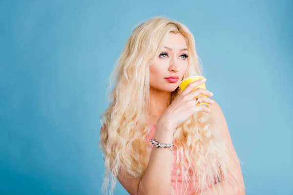 Mulher bonita no estúdio azul fundo beber café no copo de papel — Fotografia de Stock