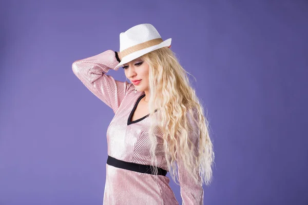 Bella giovane donna in cappello da sole su sfondo viola — Foto Stock