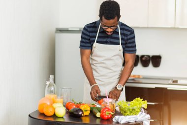 Afrikalı adam mutfakta evde sağlıklı gıda hazırlanıyor