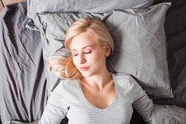 Uyku. Yatakta uyuyan genç kadın