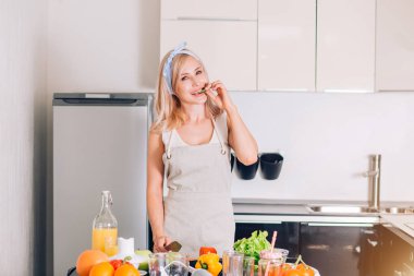 Genç bir kadın mutfakta yemek pişiriyor.