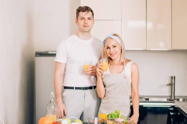 Çift mutfakta taze organik meyve suyu yapıyor.