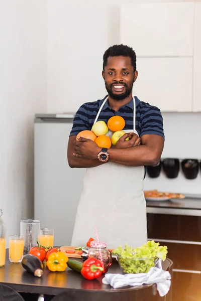 Homem africano preparando comida saudável em casa na cozinha — Fotografia de Stock