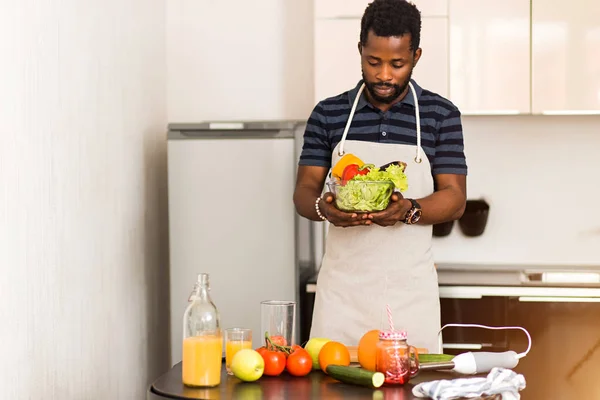 African man preparing healthy food at home in kitchen