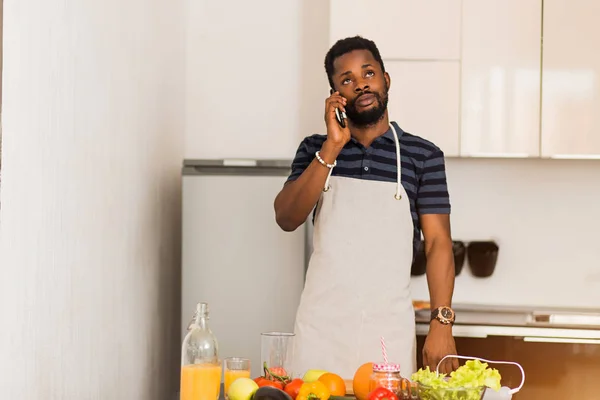 Joven hombre atractivo hablando por teléfono en la cocina — Foto de Stock