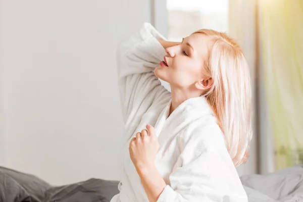 Kvinna i badrock koppla av i sängen på morgonen — Stockfoto