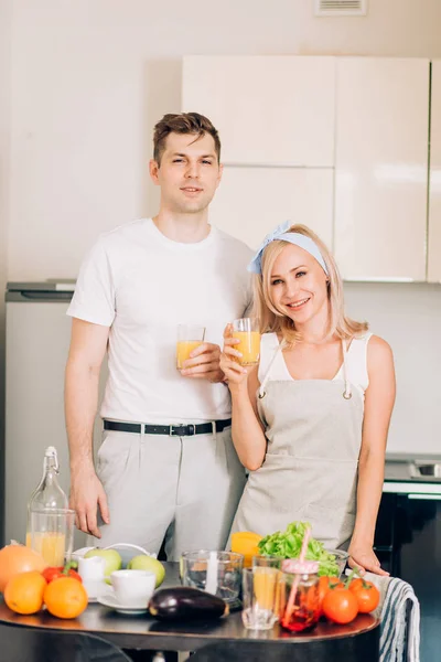 Casal fazendo suco orgânico fresco na cozinha juntos — Fotografia de Stock