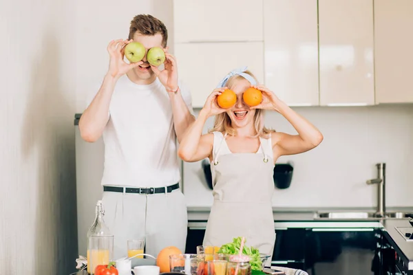 Casal fazendo suco orgânico fresco na cozinha juntos — Fotografia de Stock