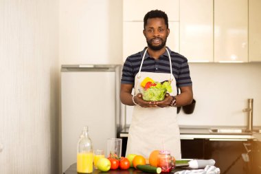Afrikalı adam mutfakta evde sağlıklı gıda hazırlanıyor