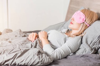 Genç kadın yatakta uyuyor.